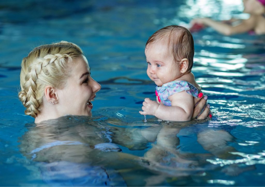 maman et son bébé dans l'eau de la piscine