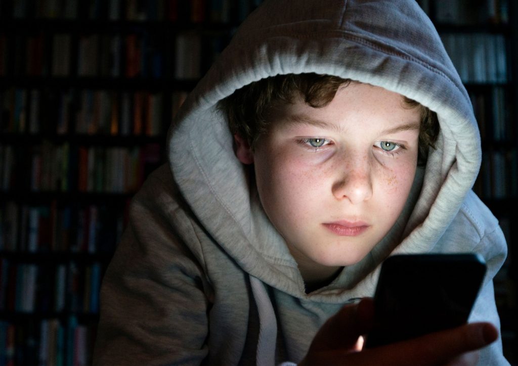enfant sur smartphone pris au piège des réseaux sociaux