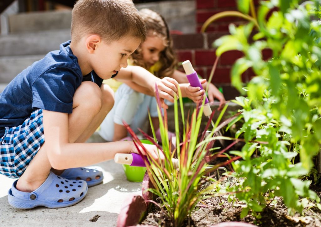 enfants qui partagent du matériel pour jardiner ensemble