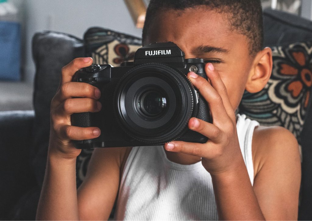 jeune enfant qui utilise un appareil photo pro